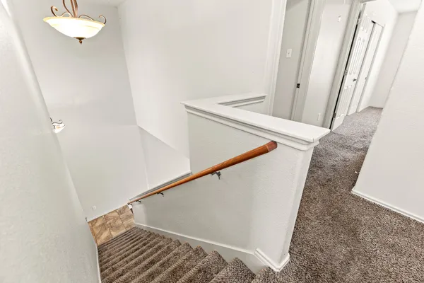 a view of staircase with white walls and railing