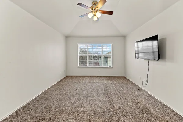 an empty room with windows and fan