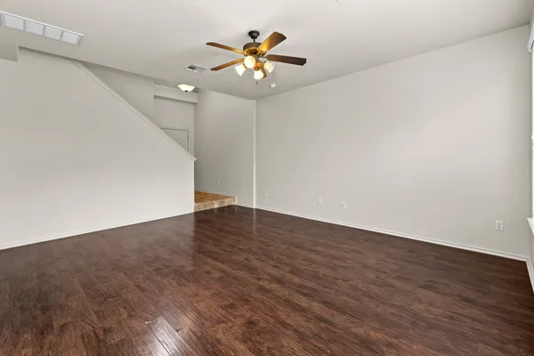 a view of an empty room with wooden floor