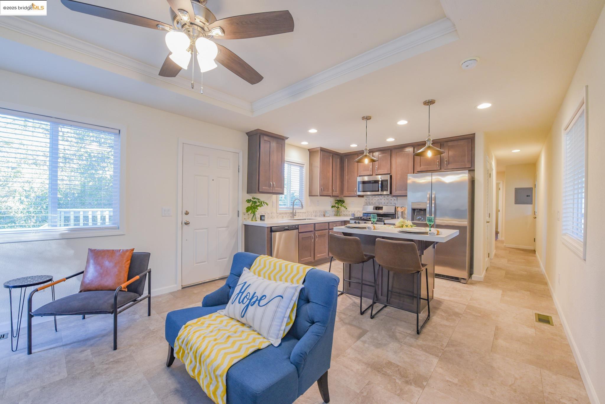 10956 Green Street Columbia, CA 95310 - Photo 13 of 45 Kitchen with a breakfast bar area, stainless steel appliances, a kitchen island, hanging light fixtures, and a tray ceiling