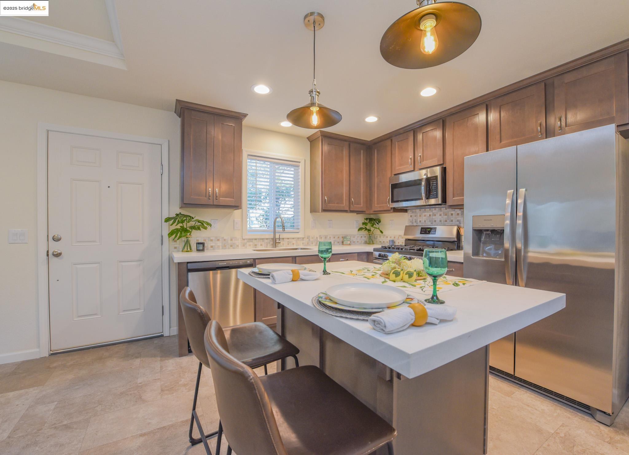 10956 Green Street Columbia, CA 95310 - Photo 9 of 45 a kitchen with a sink a kitchen island and chairs