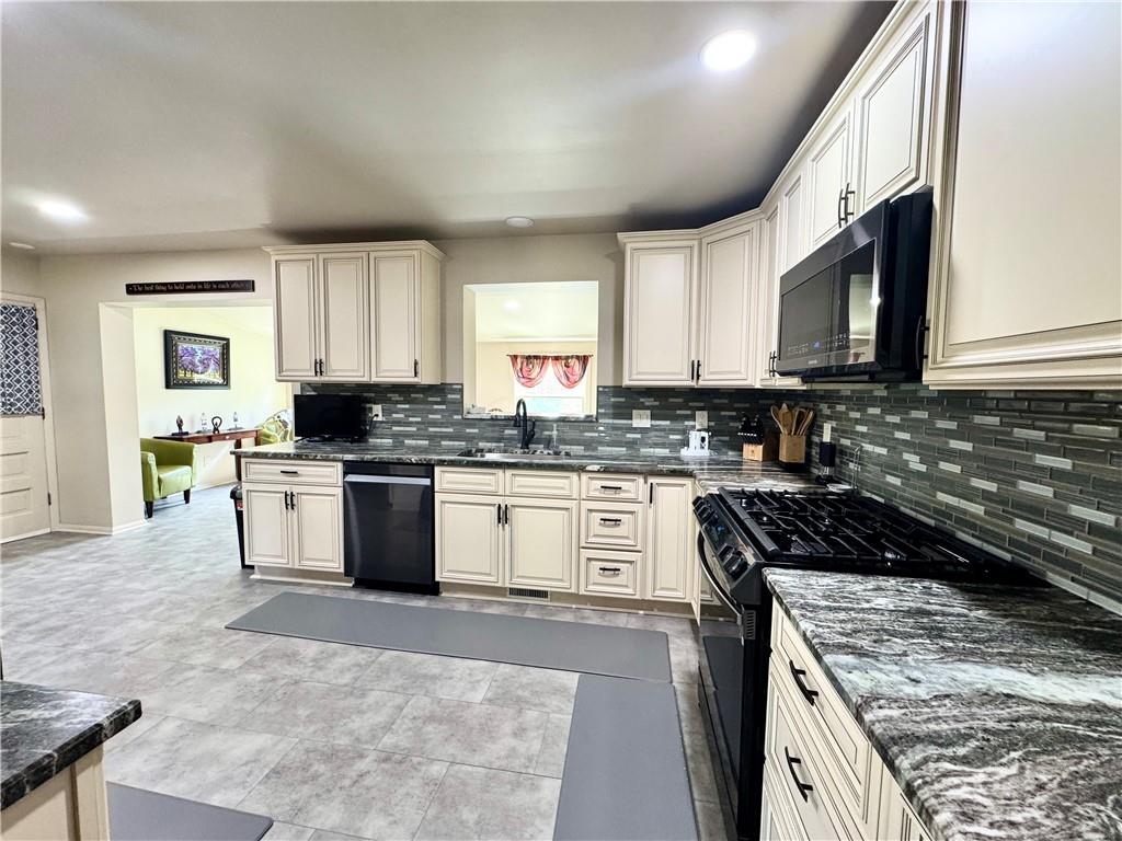824 Shenango Road New Castle, PA 16101 - Photo 11 of 34 a kitchen with granite countertop a stove sink and cabinets