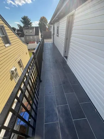 a view of an empty room with wooden floor and windows