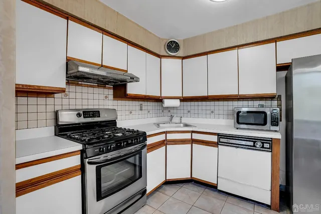 a kitchen with stainless steel appliances granite countertop a stove and a microwave