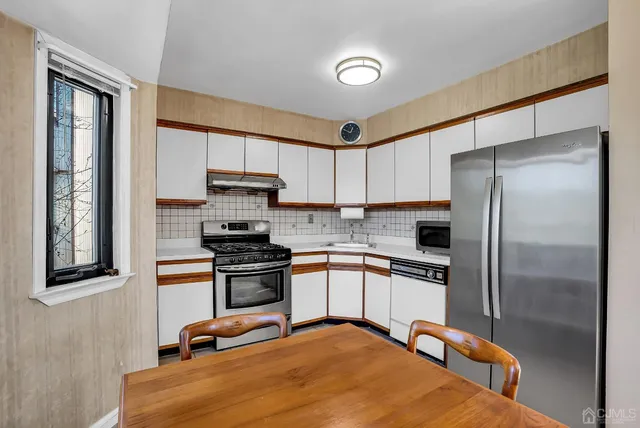a kitchen with a stove and white cabinets