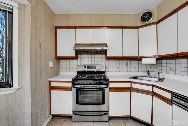 a kitchen with stainless steel appliances granite countertop a refrigerator a stove a sink a dining table and chairs