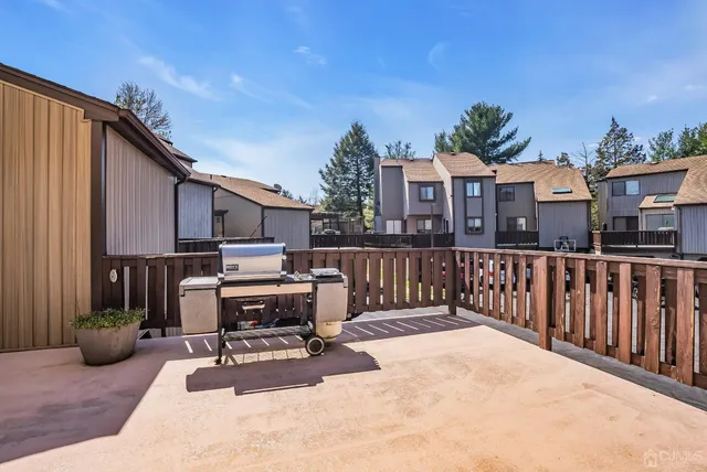 a view of a house with wooden deck and furniture
