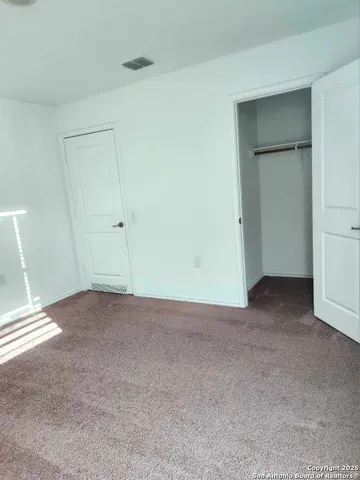 a view of an empty room and closet area