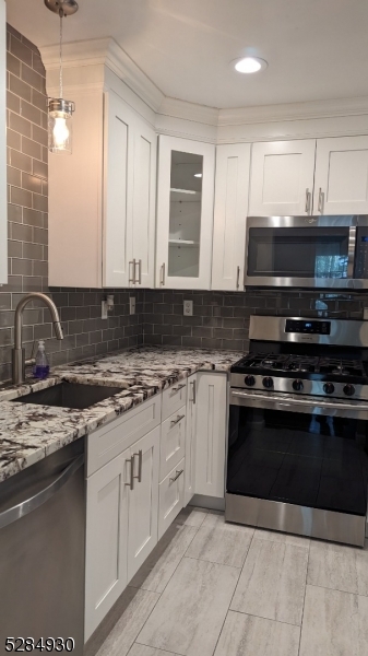 16 Cellar Avenue, Unit 16 Clark, NJ 07066 - Photo 5 of 12 a kitchen with stainless steel appliances granite countertop a stove a sink and a microwave