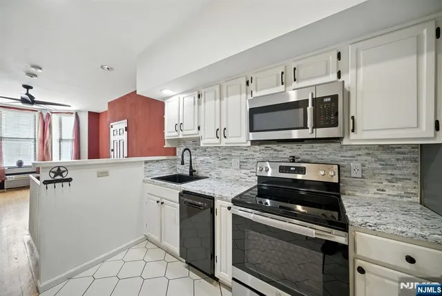 a kitchen with stainless steel appliances granite countertop a stove microwave and cabinets