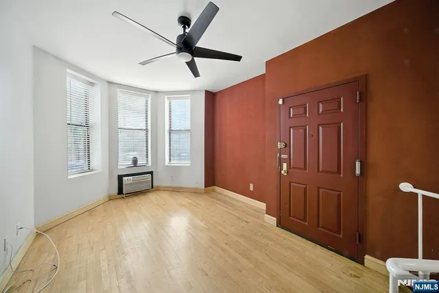 a view of a livingroom with a ceiling fan & hardwood floor