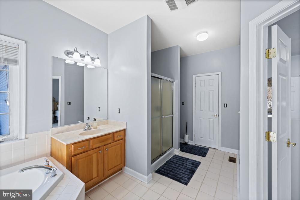 13710 Baden Naylor Road Upper Marlboro, MD 20772 - Photo 30 of 66 a spacious bathroom with a double vanity sink a mirror and a shower