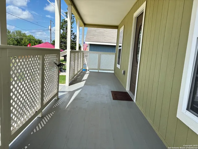 a kitchen with granite countertop a stove top oven a sink dishwasher and white cabinets with wooden floor