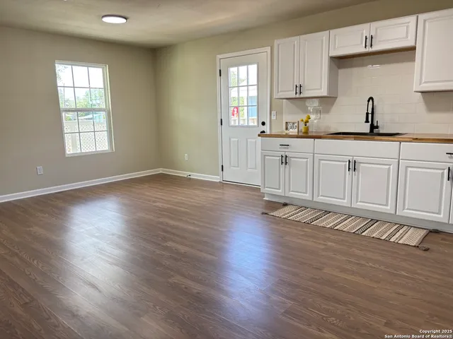 a large kitchen with cabinets and wooden floor