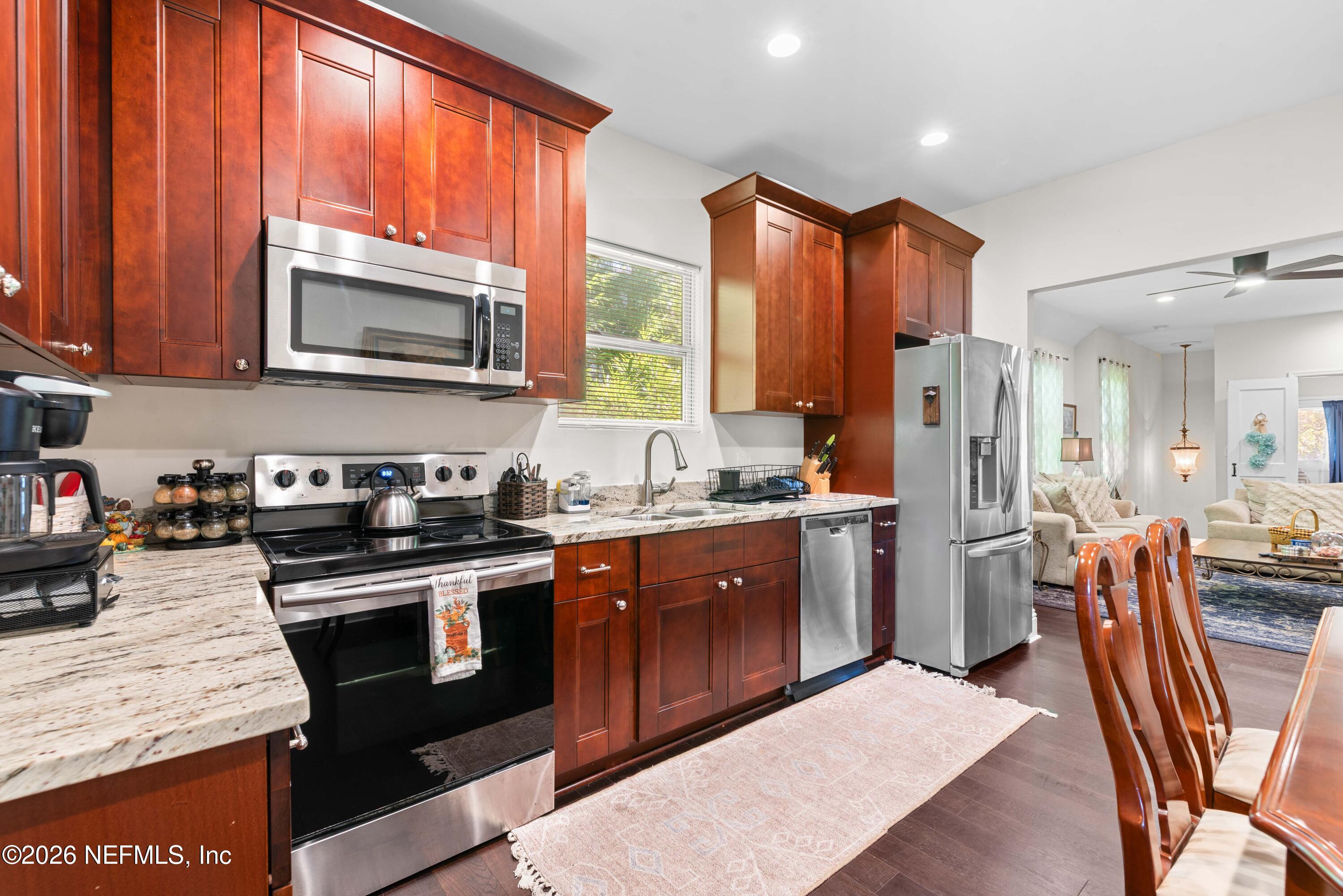 1138 Walnut Street Jacksonville, FL 32206 - Photo 24 of 37 a kitchen with stainless steel appliances granite countertop wooden cabinets a stove a sink a dining table and chairs
