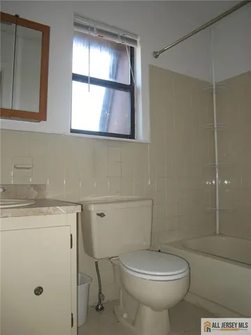 a bathroom with a toilet a sink and a window