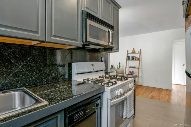 a kitchen with stainless steel appliances granite countertop a stove and a microwave