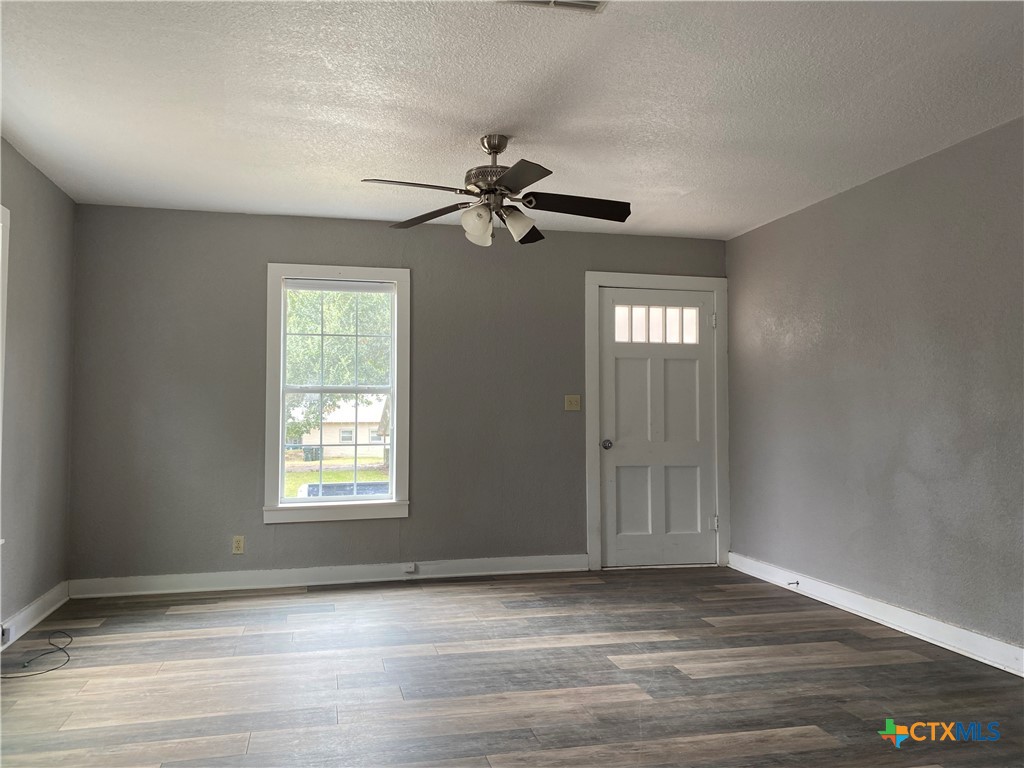 121 Fifteenth Street East Shiner, TX 77984 - Photo 5 of 17 wooden floor in an empty room with a window