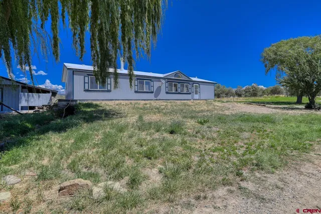 a view of a house with a yard and tree s