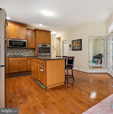 a kitchen with stainless steel appliances granite countertop a sink a stove and cabinets