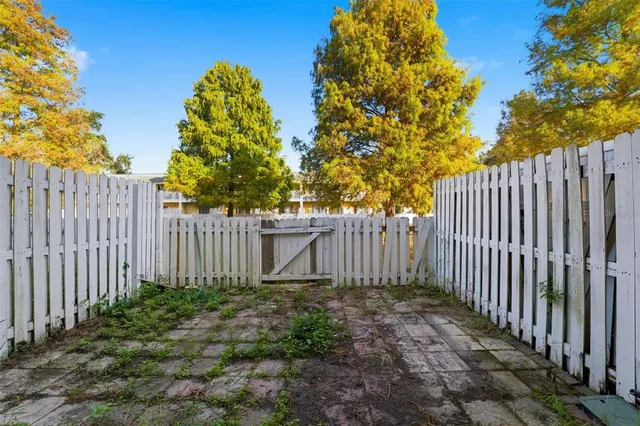 a view of small garden with wooden fence