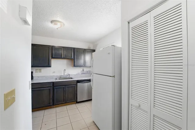 a kitchen with stainless steel appliances a sink a refrigerator and cabinets