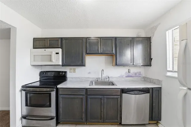 a kitchen with a sink stove and microwave
