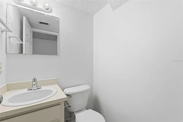 a bathroom with a sink a toilet and mirror