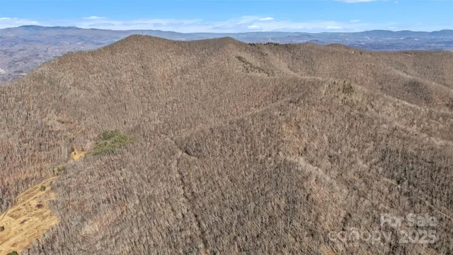 a view of mountain with sunset in background