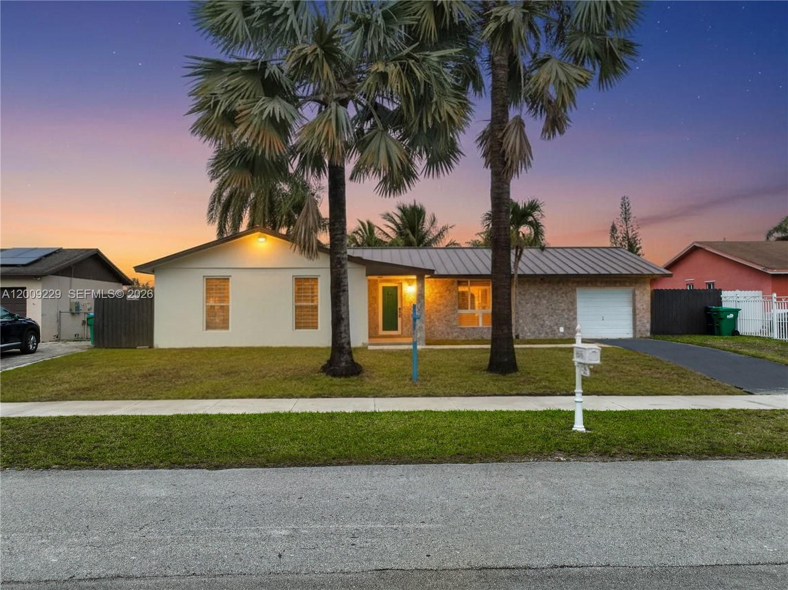 13251 Southwest 254th Terrace Homestead, FL 33032 - Photo 2 of 21 a front view of a house with a yard and garage