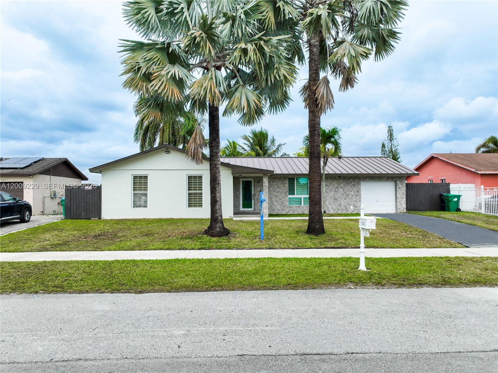 13251 Southwest 254th Terrace Homestead, FL 33032 - Photo 3 of 21 a front view of a house with a yard and garage