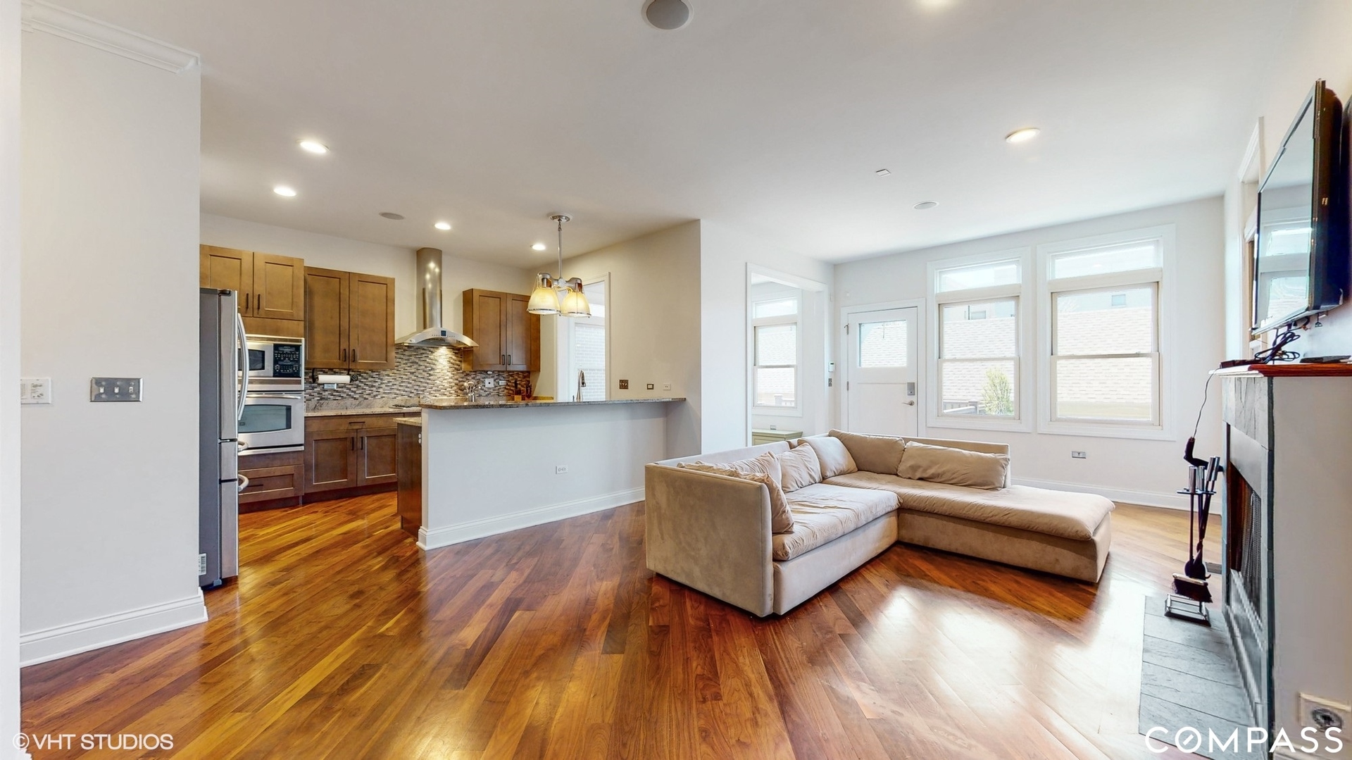 1412 South Emerald Avenue Chicago, IL 60607 - Photo 6 of 33 a living room with kitchen island granite countertop wooden floor furniture and a kitchen view