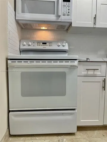 a white refrigerator freezer and a stove sitting inside of a kitchen