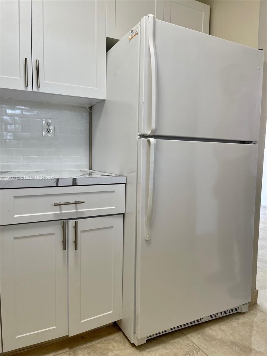 1725 West 60th Street, Unit F304 Hialeah, FL 33012 - Photo 13 of 26 a white refrigerator freezer and a stove sitting inside of a kitchen