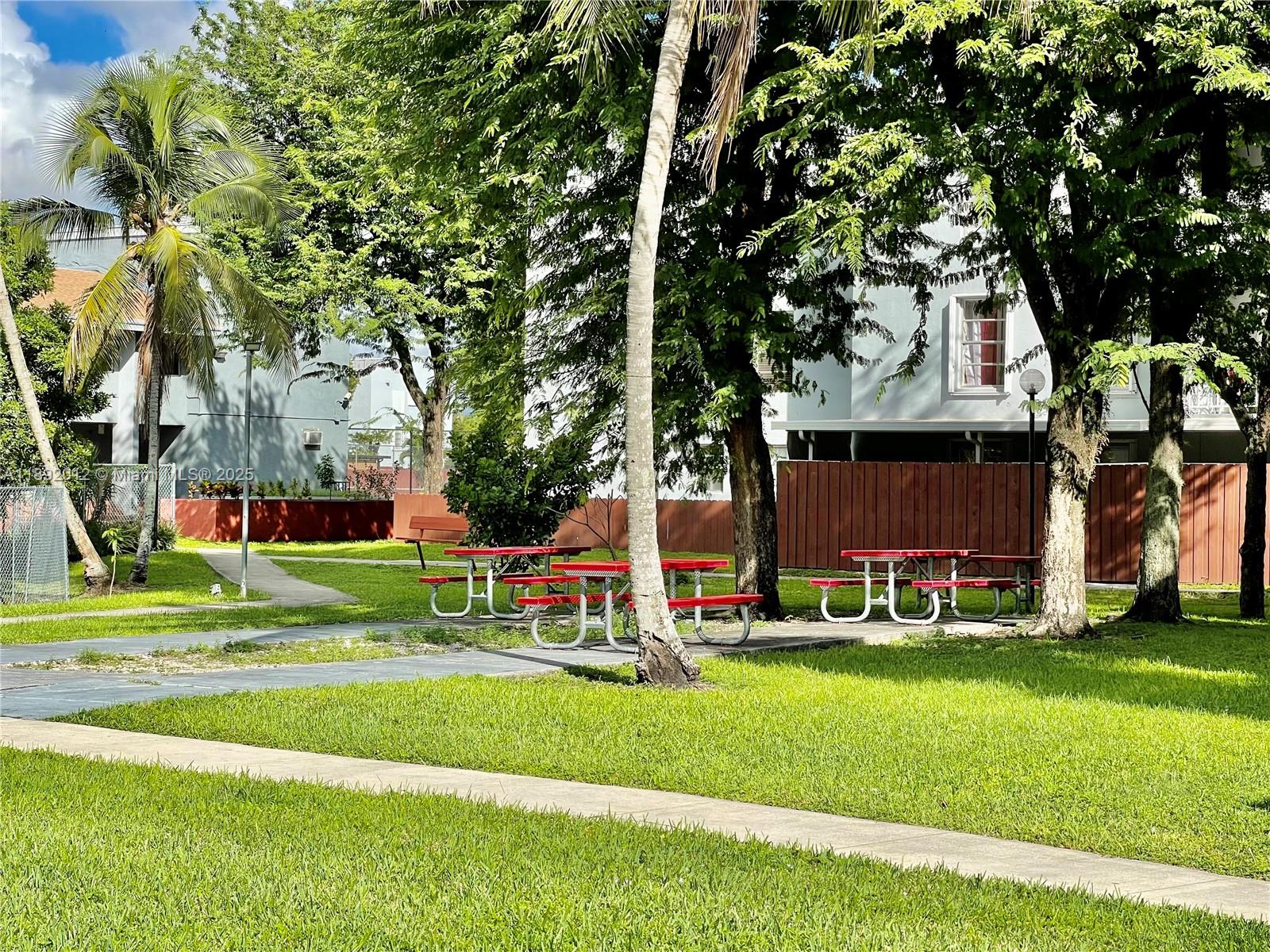 1725 West 60th Street, Unit F304 Hialeah, FL 33012 - Photo 6 of 26 a front view of a house with a yard table and trees