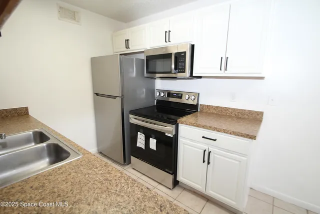a kitchen with stainless steel appliances granite countertop a refrigerator and a stove