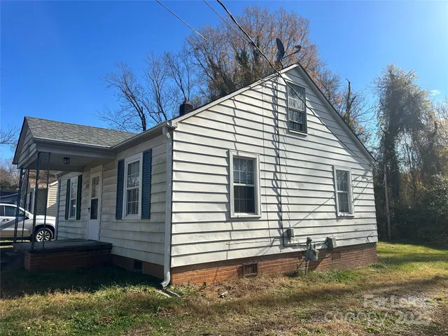 a view of a house with a yard and lawn chairs
