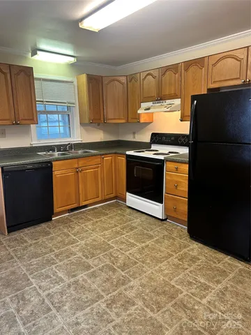 a kitchen with granite countertop a refrigerator and a stove top oven