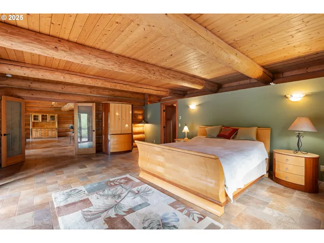 a spacious bedroom with a bed and a lamp