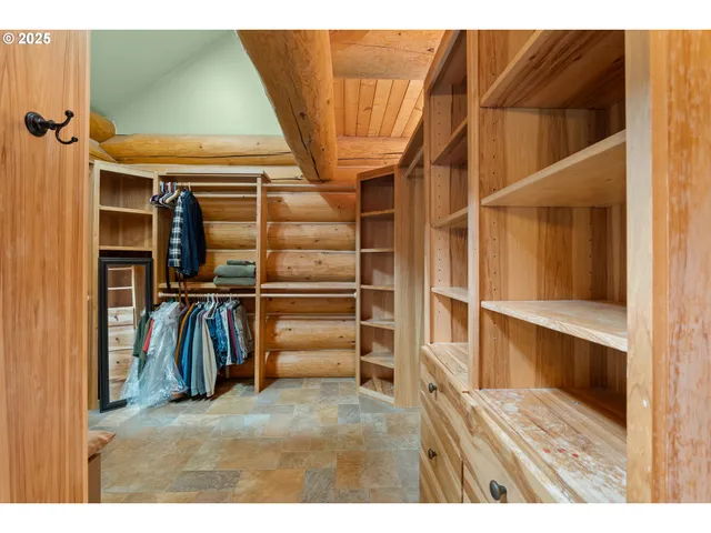 a view of walk in closet with clothes and shoes