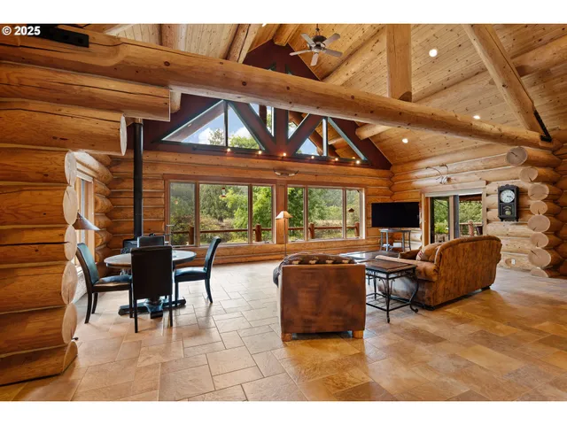 a living room with furniture a flat screen tv and floor to ceiling window