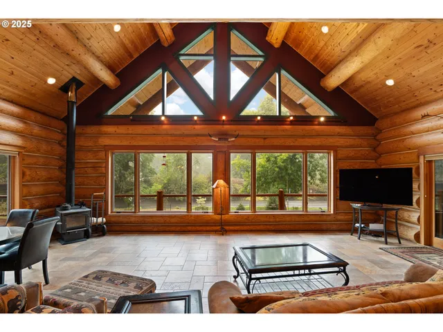 a living room with furniture a flat screen tv and a large window