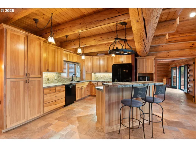 a kitchen with stainless steel appliances kitchen island granite countertop a table and chairs