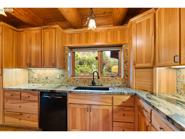 a kitchen with granite countertop wooden cabinets and a large window
