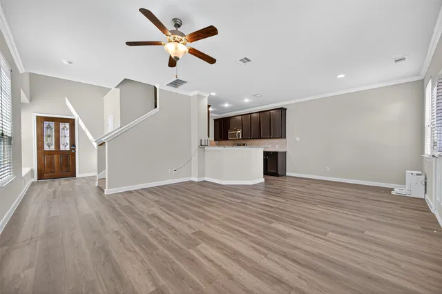 an empty room with wooden floor and windows