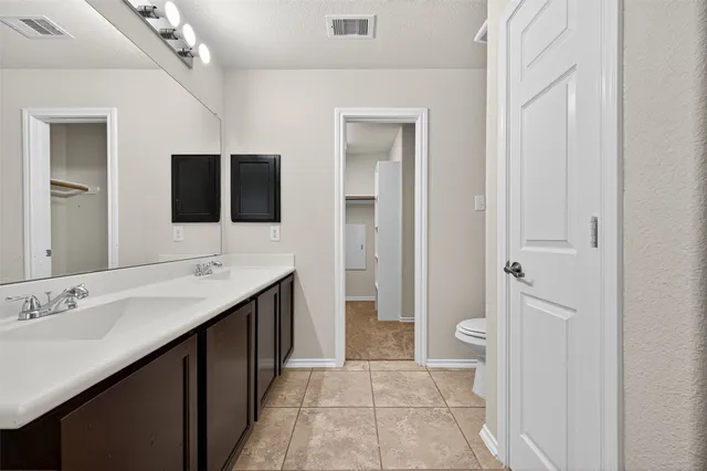 a bathroom with a tub a sink double vanity and a mirror