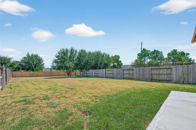 a view of a house with a small yard and wooden fence