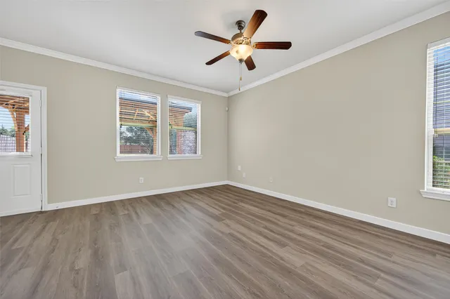 a view of an empty room with wooden floor