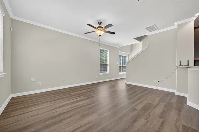 a view of empty room with wooden floor and window