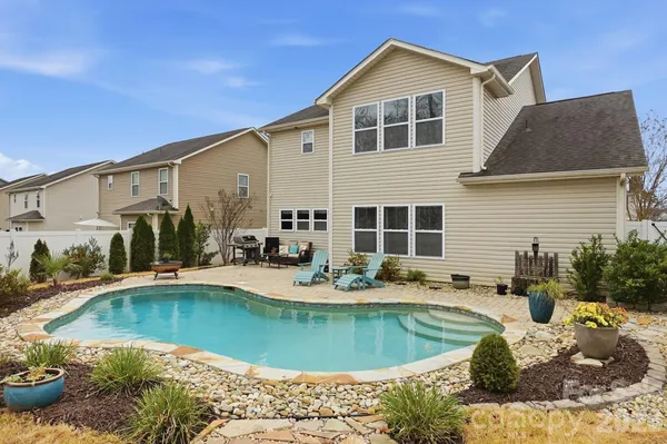 a view of a house with swimming pool and sitting area